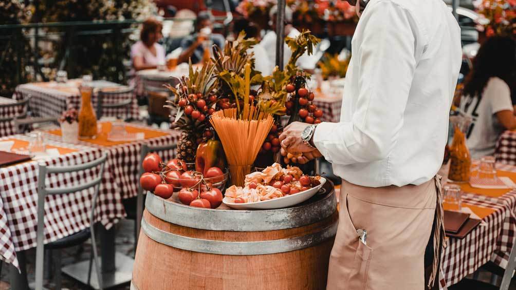 Image description: Person standing near fresh food ingredients at an outdoor market.