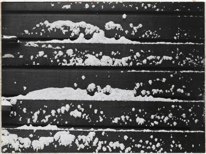 A close-up of snow on wood panels