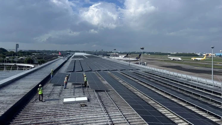 Workers installing solar panels on Terminal 3 rooftop
