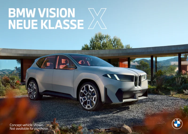 Neue Klasse X parked on gravel in front of trees and plants. Concept vehicle shown. Not available for purchase. BMW.