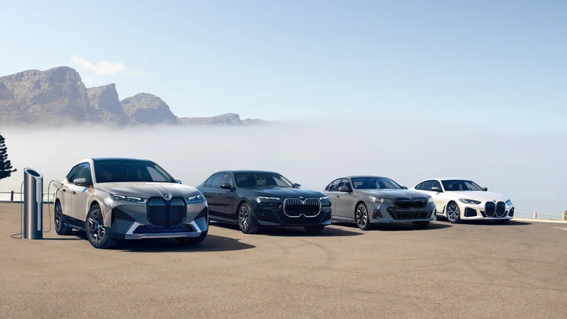 BMW iX, i7, i5, i4 parked in front of mountains.