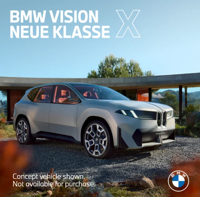 Neue Klasse X parked on gravel in front of trees and plants. Concept vehicle shown. Not available for purchase. BMW.