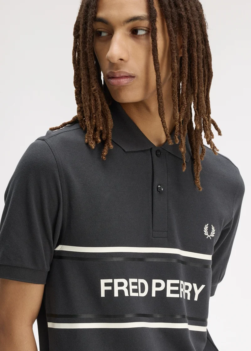 New Releases Men: Model wearing a Fred Perry Graphic Polo Shirt in Anchor Grey