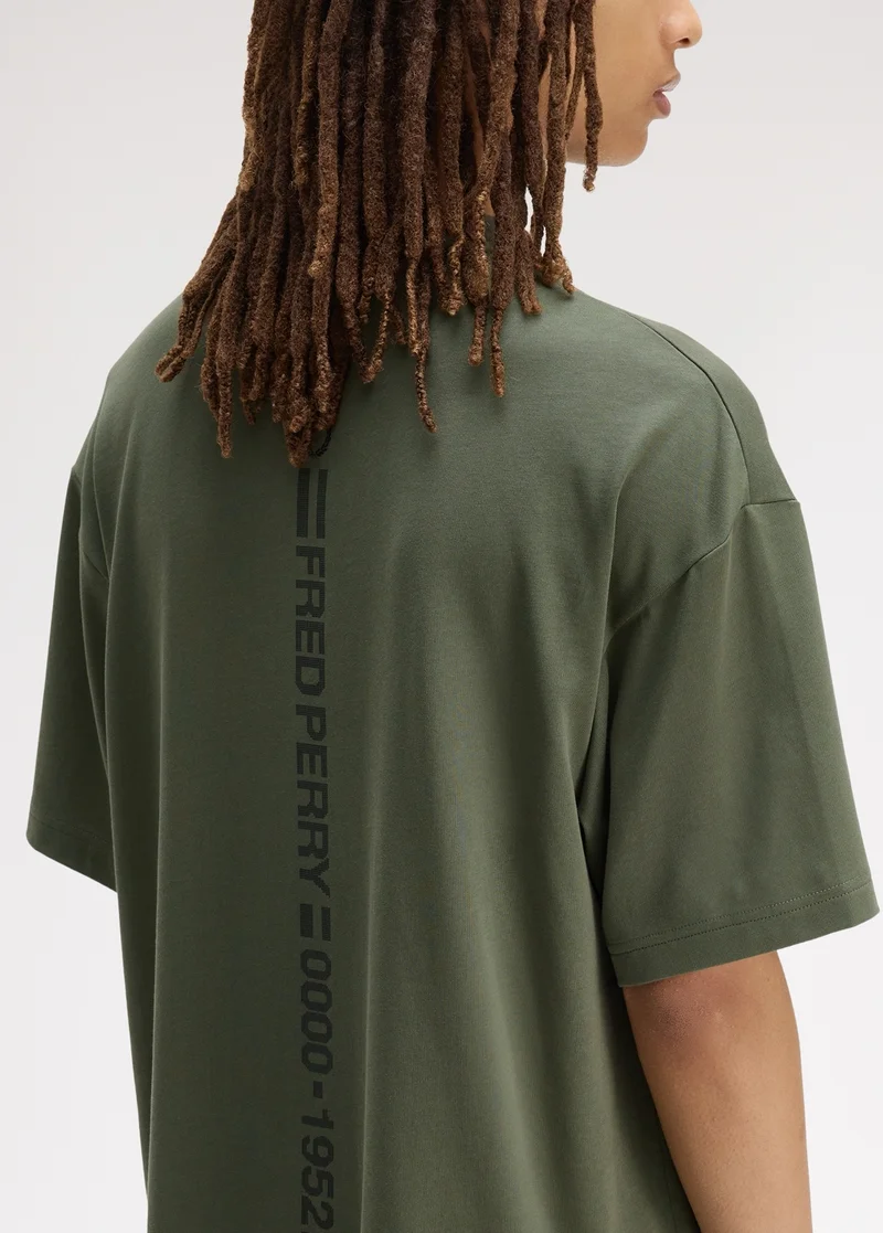 New Releases: Male model wearing a Fred Perry Glitch Graphic T-Shirt in Laurel Wreath Green
