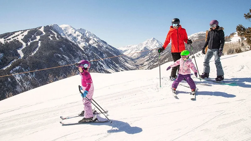 Image description: Family skiing together at Aspen Snowmass