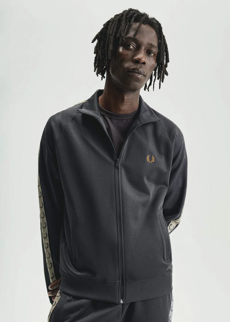 Male model wearing grey zip up track jacket with taping detail