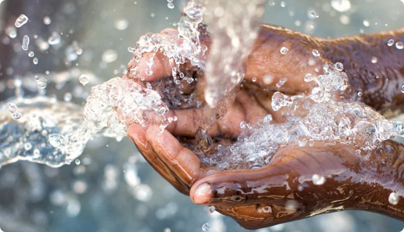 Water being poured into someone's open hands.