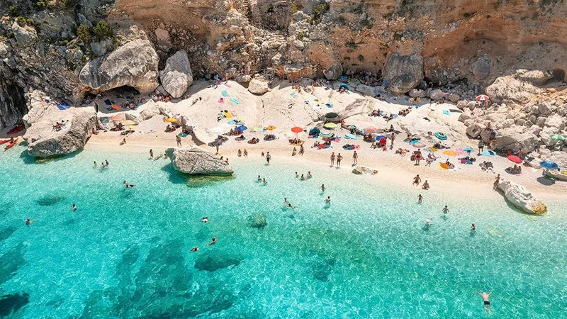 Image description: People swimming at Cala Goloritze, Sardinia.