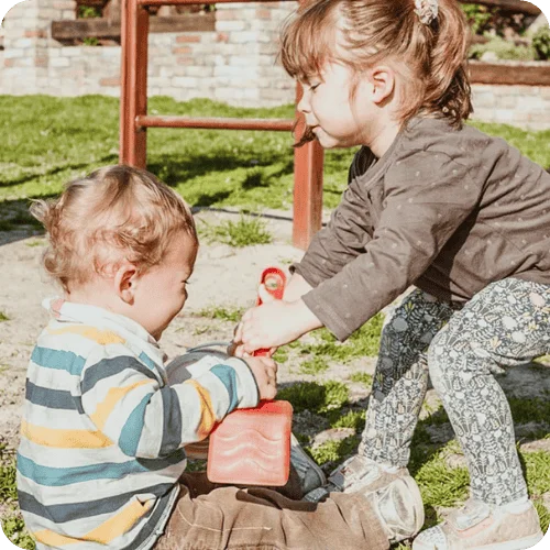 a toddler stealing her little brother's shovel a toddler stealing her little brother's shovel