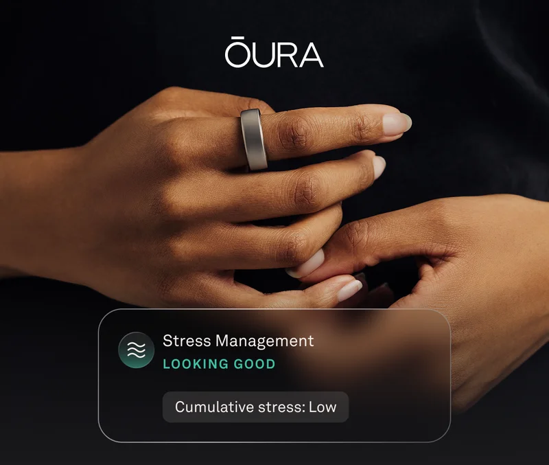 Hand with brushed titanium ring and stress management UI overlay showcasing low cumulative stress levels