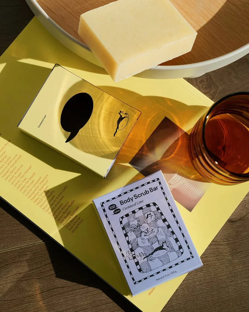 A haphazard flat lay of the cornmeal bar and its box and glasses and a book