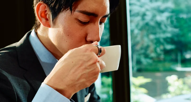Person drinking from a mug wearing Oura Ring