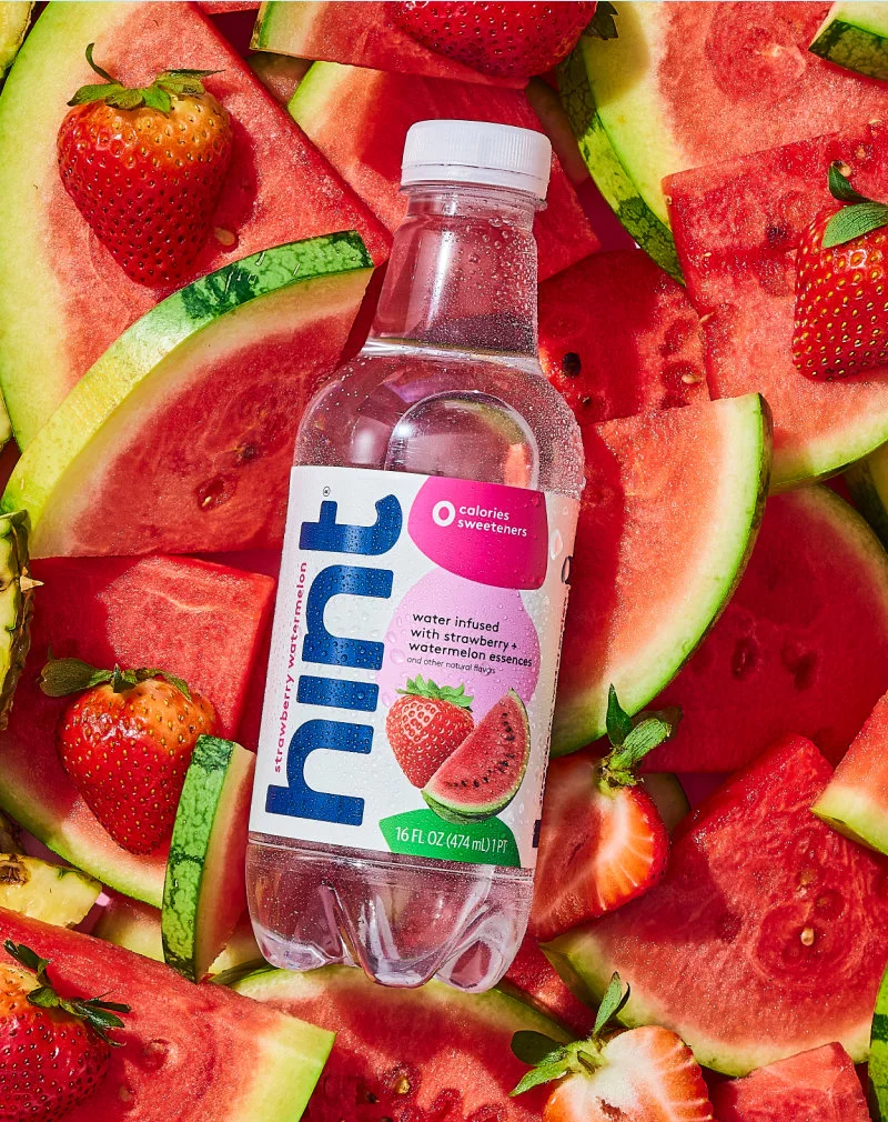 Strawberry Watermelon bottle on a many fresh strawberries and watermelons