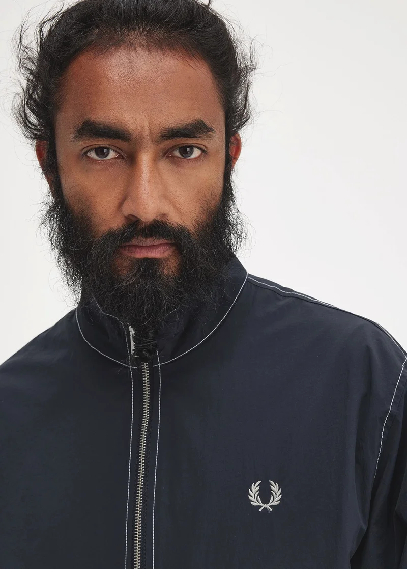 Man wearing a navy blue leight-weight zip jacket