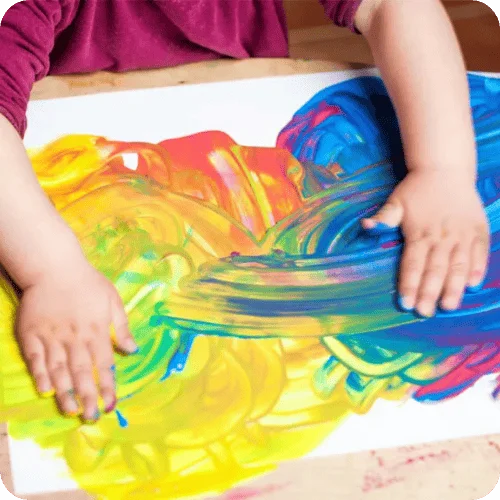 a kid making finger paint art for a story on what to do with your kid's artwork a kid making finger paint art for a story on what to do with your kid's artwork