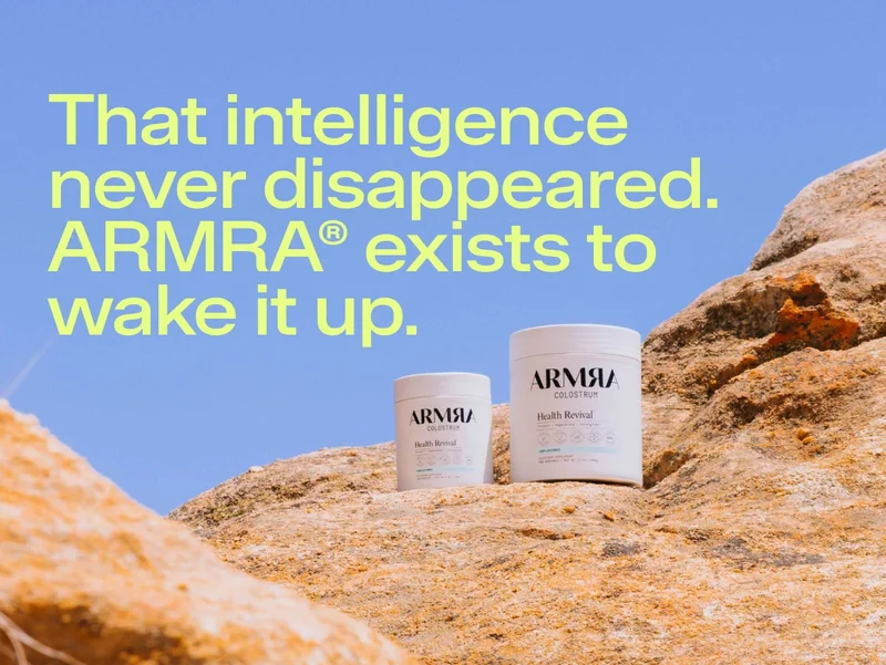 Two jars of ARMRA Colostrum displayed on sunlit rocks outdoors, emphasizing nature, durability, and simplicity.