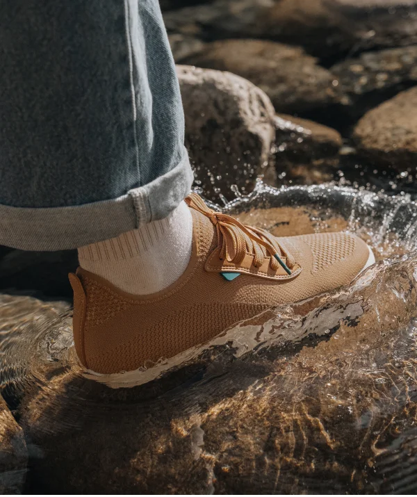 Graphic of someone stepping in a stream wearing their Weekend Sneakers in Oak Brown.