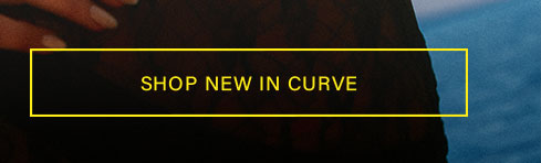 Yellow 'SHOP NEW IN CURVE' button over a person in dark clothing with manicured hand, promoting the latest plus size fashion collection.