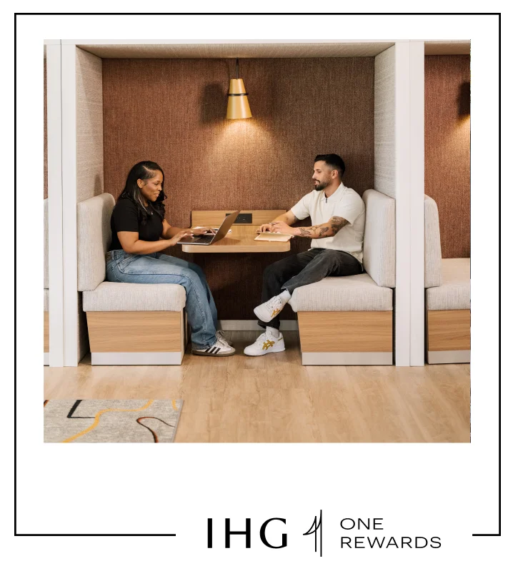 Two people work in a booth at Atwell Suites.