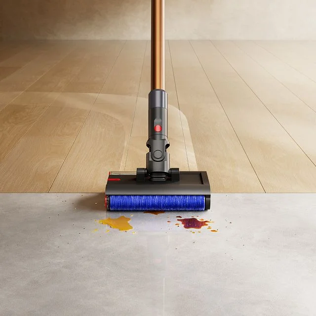 Close-up of the Dyson PencilWash cleaner head as it cleans a spill between hard floor types