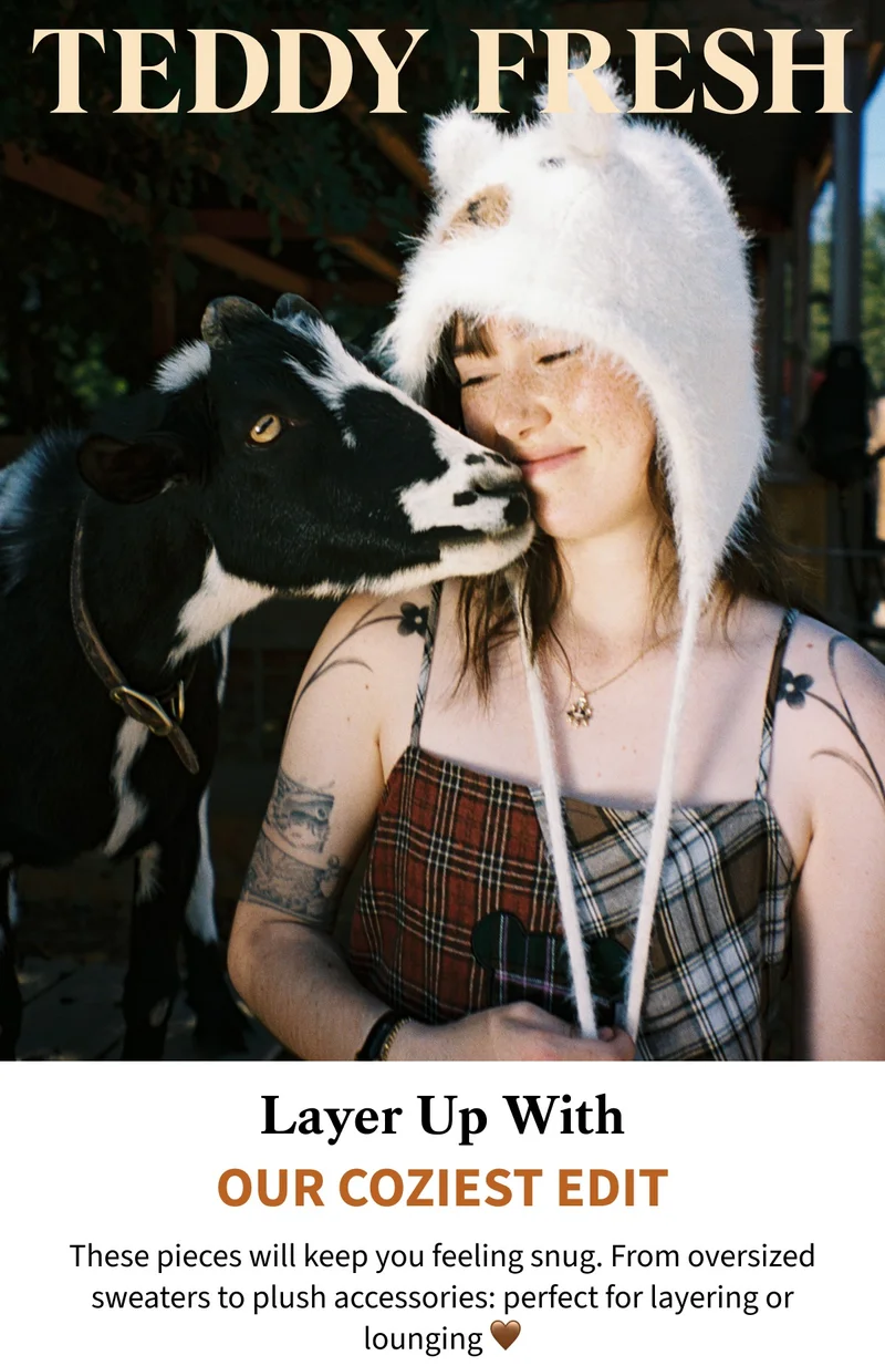 Our model wearing the Fuzzy Bear ear bonnet whilst next to a cute goat.
