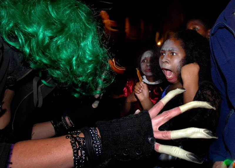 UNITED STATES - OCTOBER 31: Dressed as a witch, Susan Bachurski scares Tyla Barksdale, 11, outside her East Capitol Street home on Halloween night.