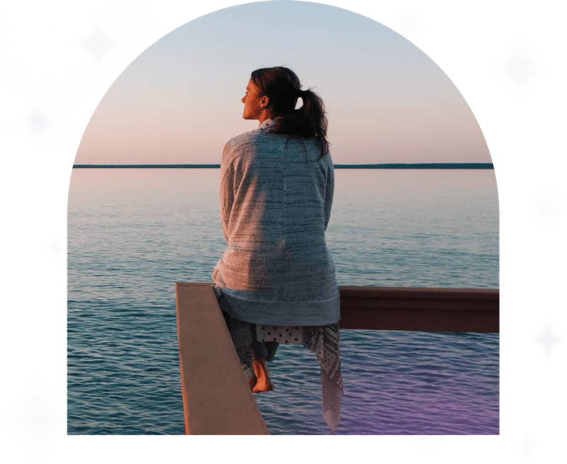 Young woman sitting on edge looks out at view