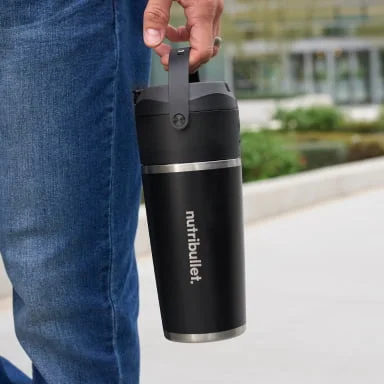 A person holds a sleek black nutribullet Flip