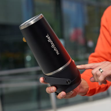 A person holds a sleek black nutribullet Flip