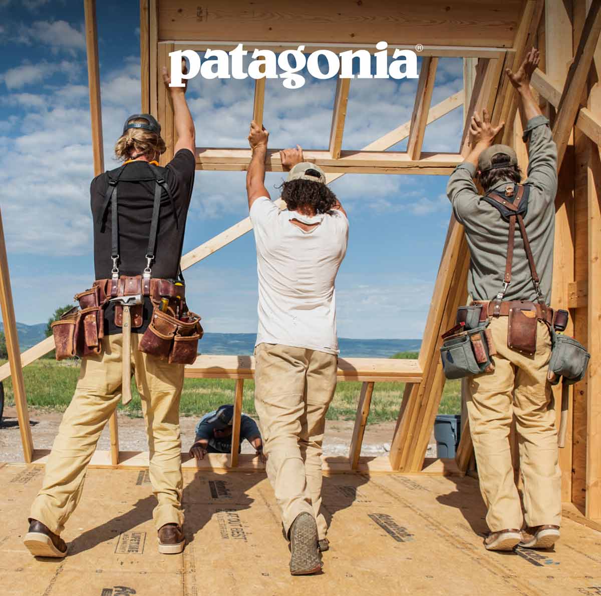 Patagonia. Three carpenters raise a framed wall on a home build site.