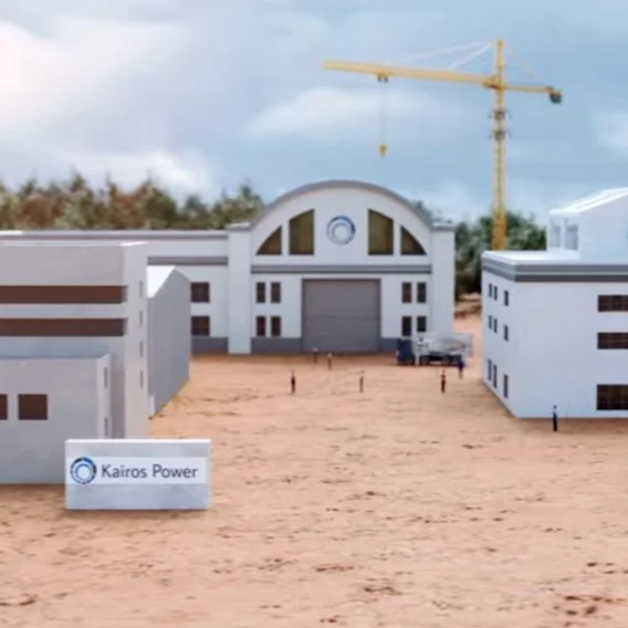 A miniature model of a power facility with buildings, a construction crane and a 'Kairos Power' sign in the foreground.