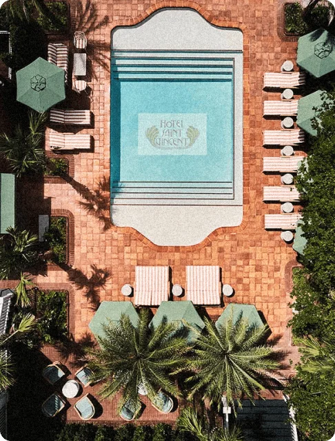 Image Description: An aerial shot of the pool, lounge chairs, and poolside parasols of Hotel Saint Vincent in New Orleans