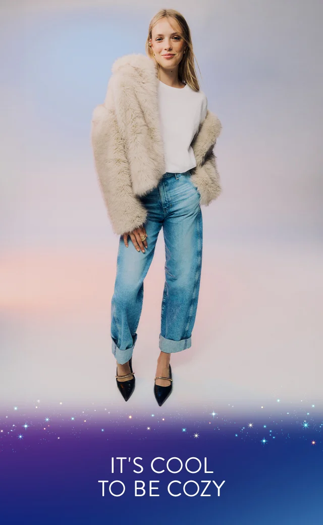 A woman wearing a faux-fur coat with blue jeans.