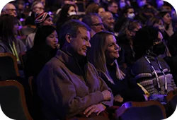 A man and a woman sitting in a crowded theater.