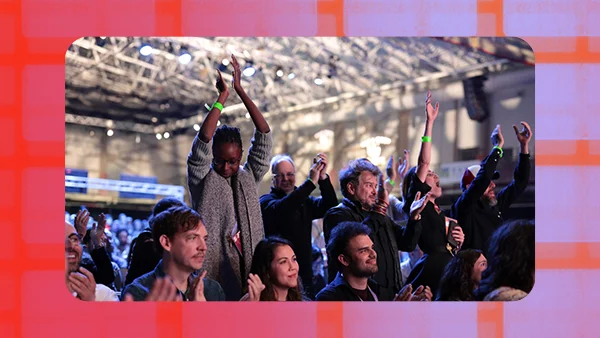 Festival attendees standing up and cheering at a Festival event.