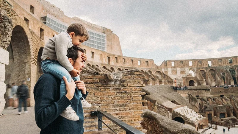Image description: Father and son looking at Roman ruins in Rome, Italy