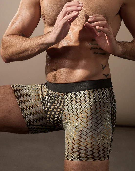an wearing patterned SAXX Smooth Flex boxer briefs in a studio setting.