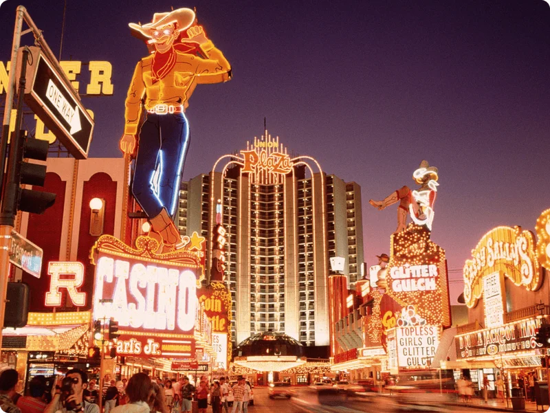 Image Description: Travelers taking photos of neon signs along Fremont Street in Las Vegas