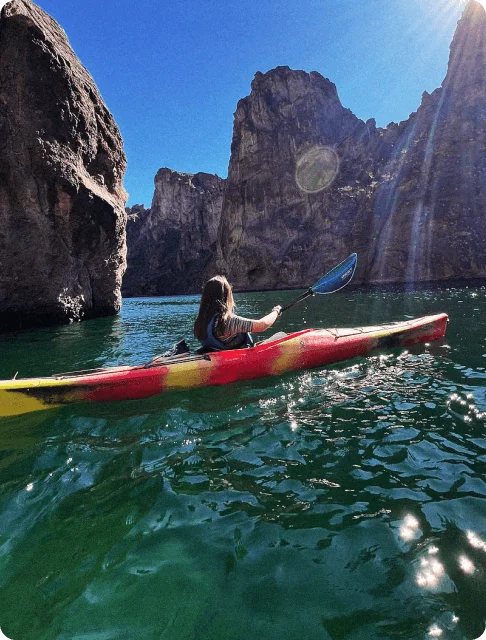 Image Description: A traveler kayaking on the Colorado River, surrounded by rocky mountains
