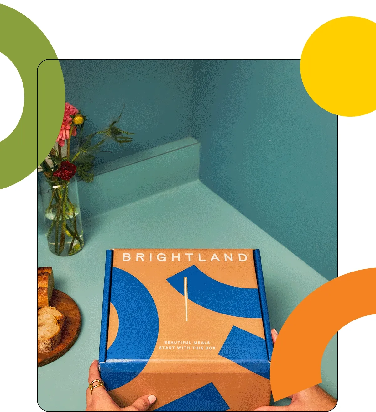 A picture of a nicely designed Brightland gift box being opened with two olive oils inside.