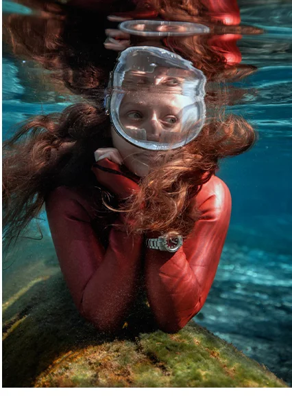 Diver in a red wetsuit wearing a Promaster Dive
