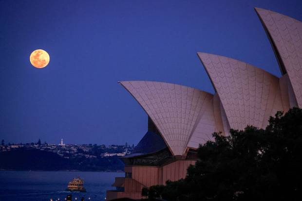The full moon, a supermoon also known as the "Harvest Moon", rises above Macquarie Lighthouse and the Sydney Opera House in Sydney on September 29, 2023.