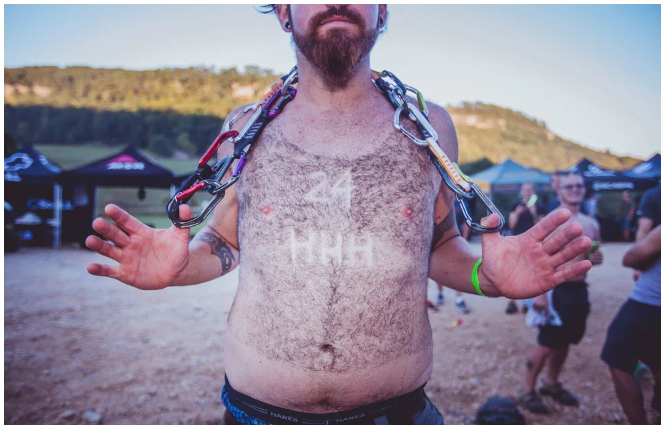 A climber reveals chest hair shaved to look like a 24 Hours of Horseshoe Hell tank top.