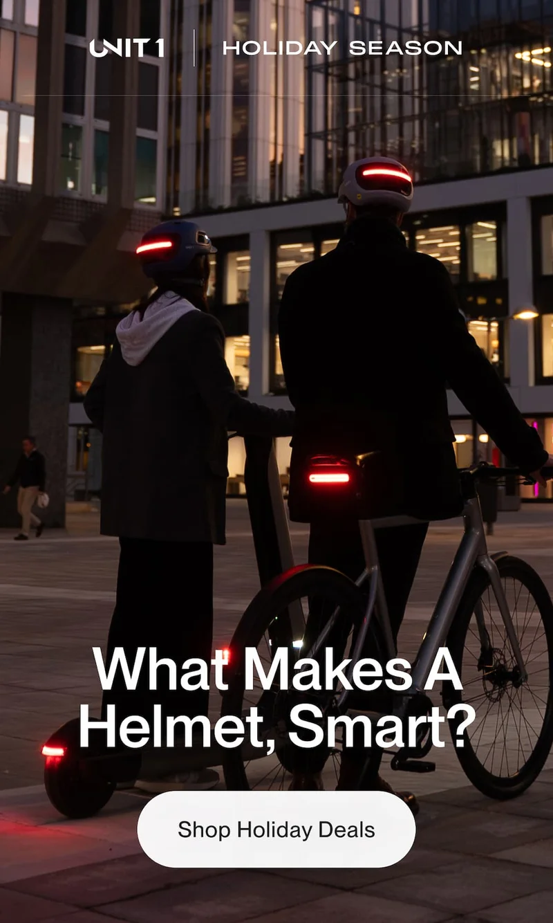 Two riders wearing UNIT 1 smart helmets with red rear lights at dusk. Text: What Makes A Helmet, Smart?