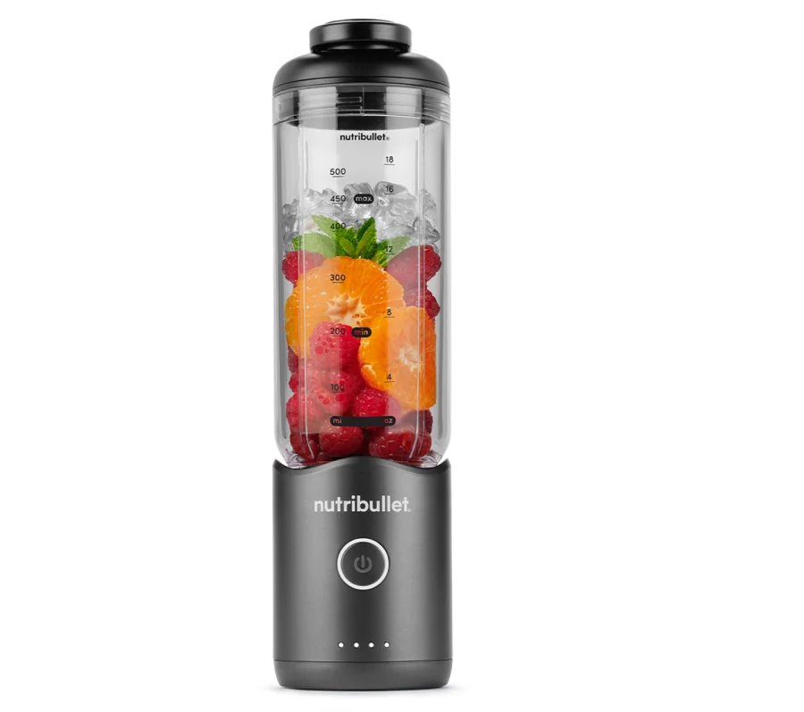 A dark grey personal nutribullet Flex blender filled with raspberries, orange slices, mint, and ice on a white background.