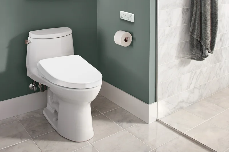 A Ultramax S7 WASHLET+ toilet in a sunlit bathroom next to a glass enclosed shower