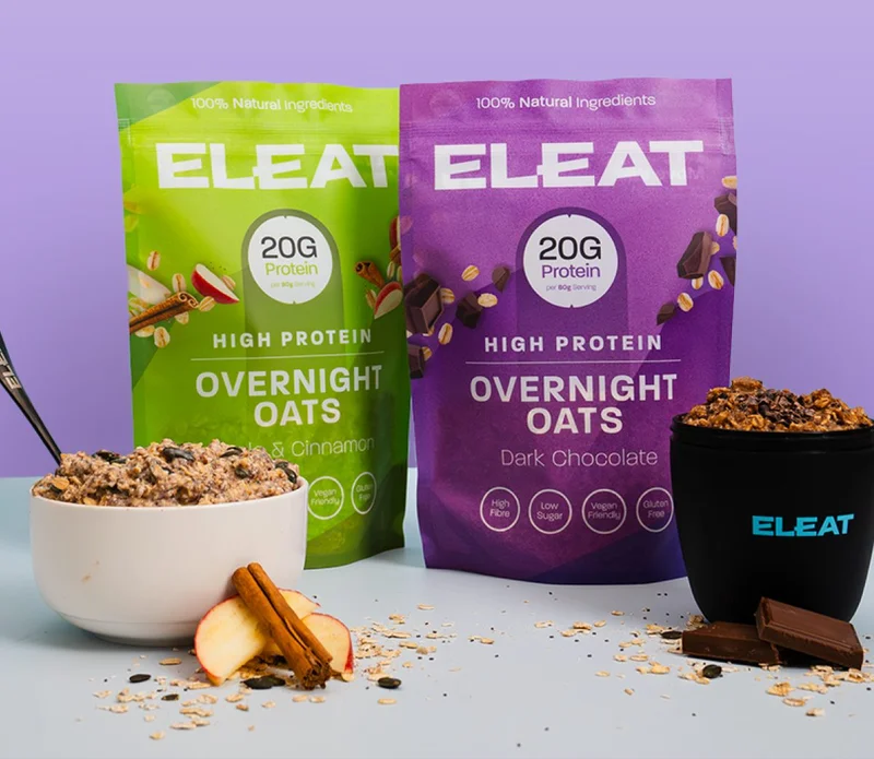 Two bags of overnight oats in flavors apple cinnamon and dark chocolate, with a bowl and cup.