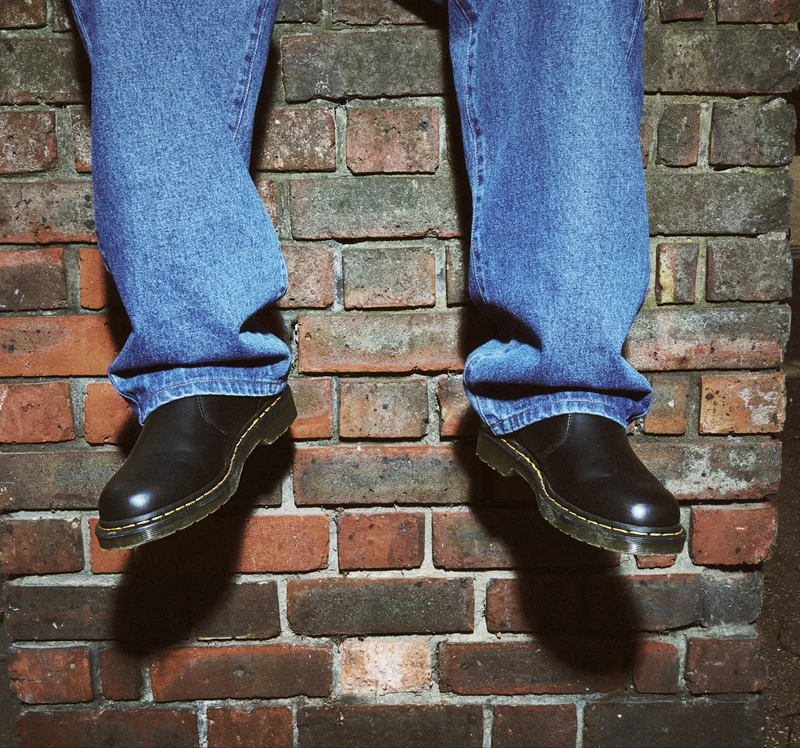 Person wearing denim and Dr. Martens footwear