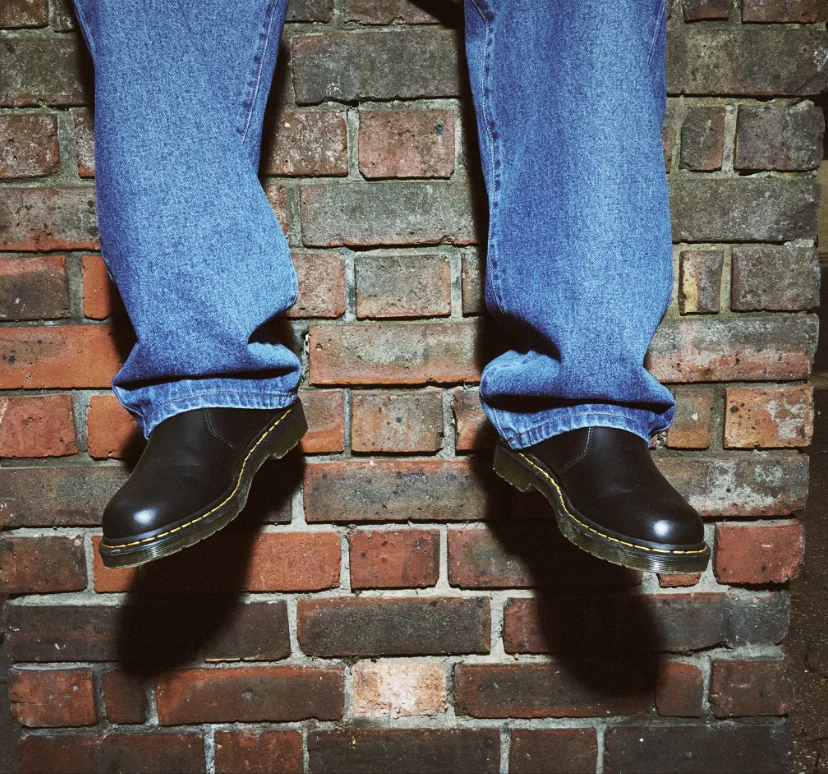 Person wearing denim and Dr. Martens footwear