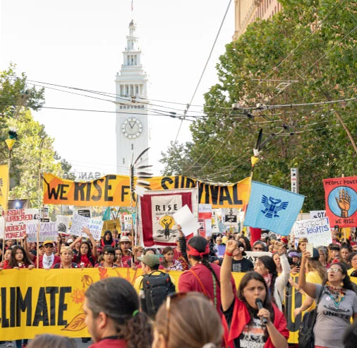 Advocate for climate solutions. Protestors hold signs at a climate march.